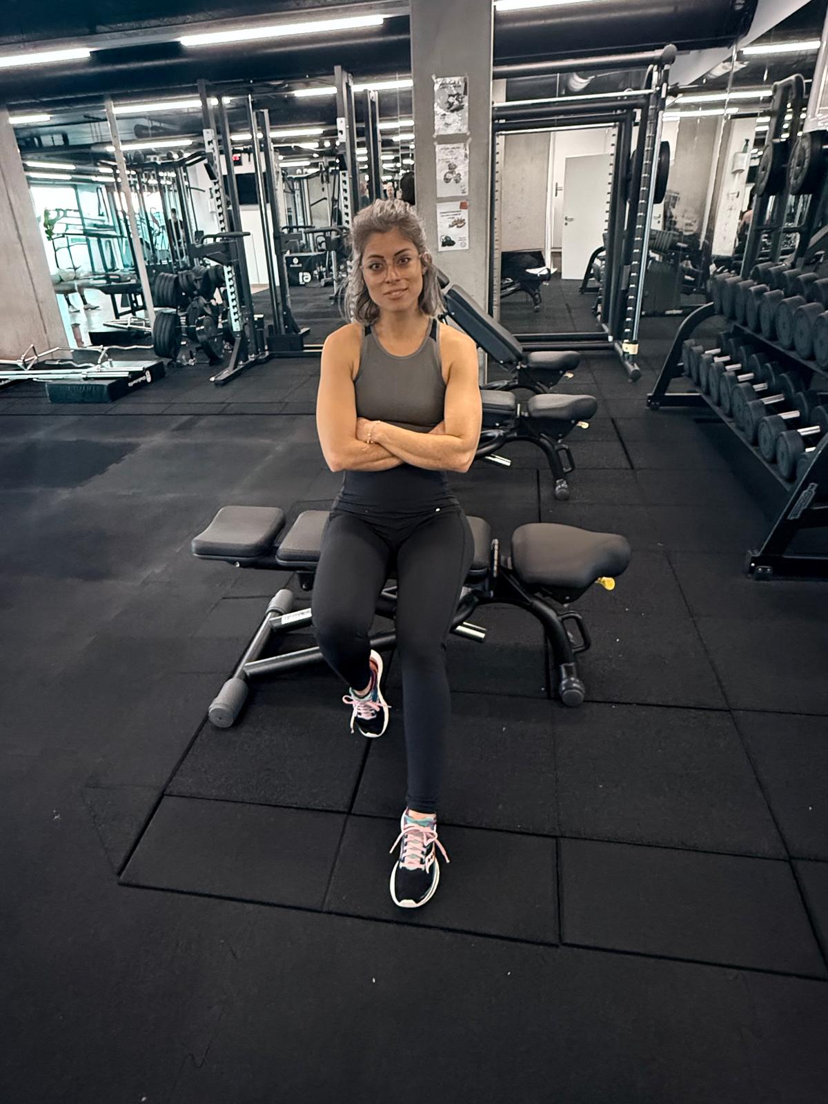 Coach de fitness posant dans une salle de musculation