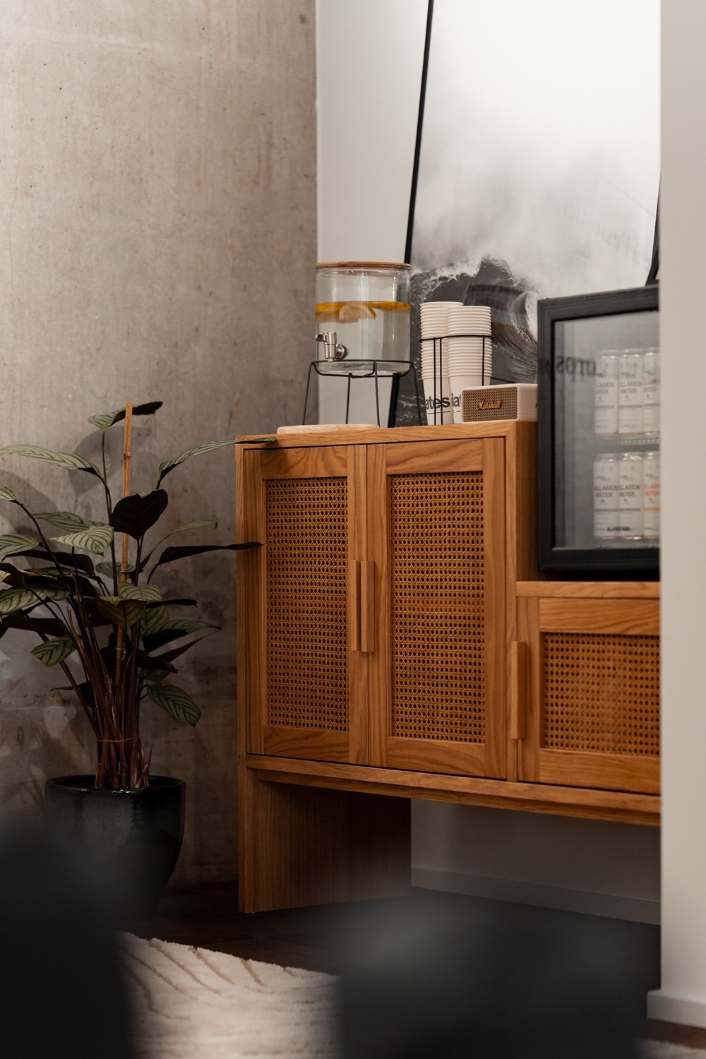 Buffet en bois avec fontaine &agrave; eau citronn&eacute;e et plante verte